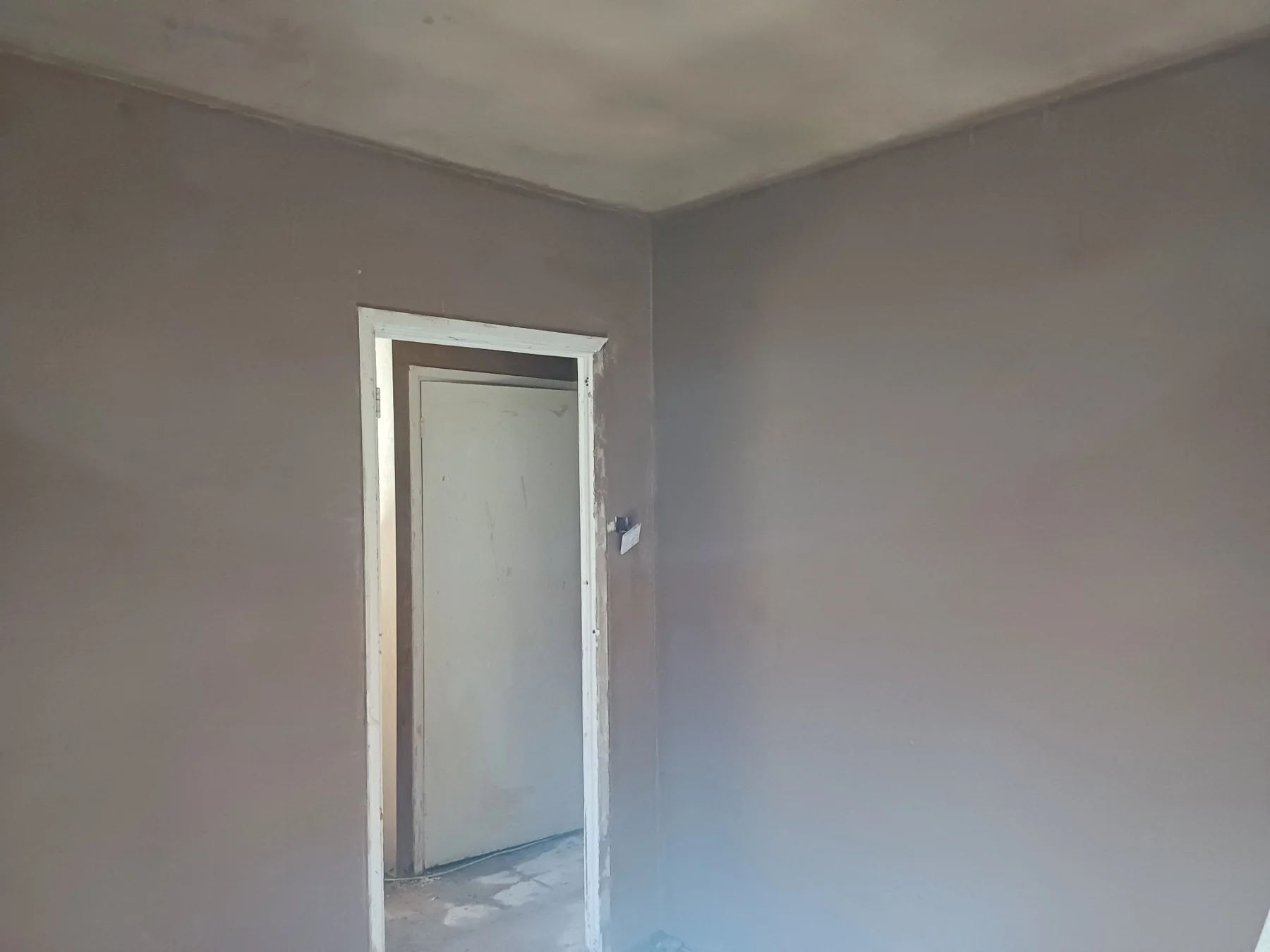 Skimmed walls around an interior doorway in a three-bedroom house in Brentford.