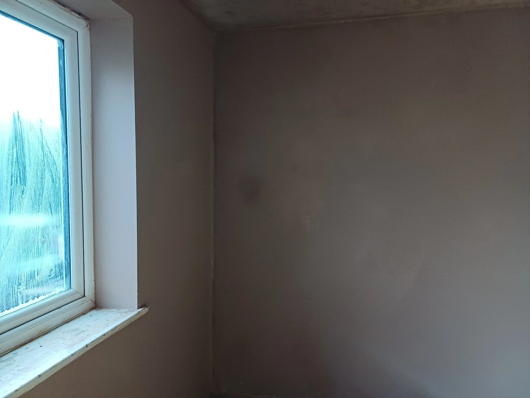 Fresh plaster on a wall and window reveal in the Brentford house.