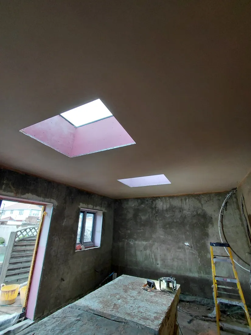 Interior extension with walls in different stages of rendering and skimming