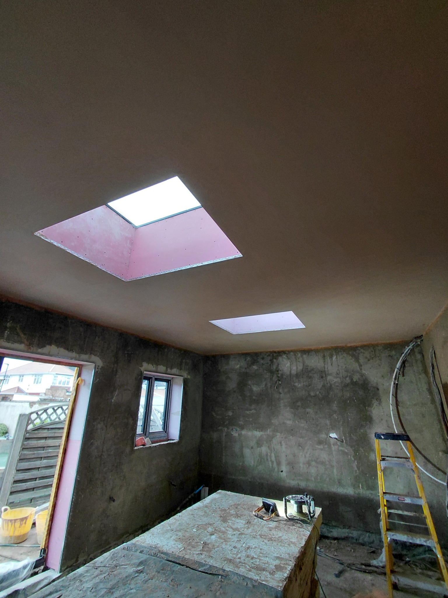 Interior extension with walls in different stages of rendering and skimming