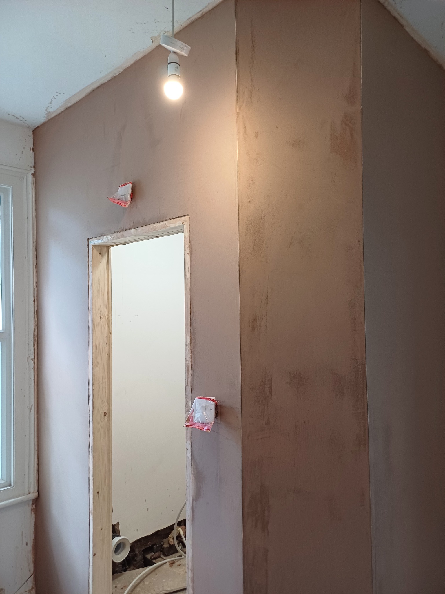 Fresh plaster finish on an interior wall near a doorway