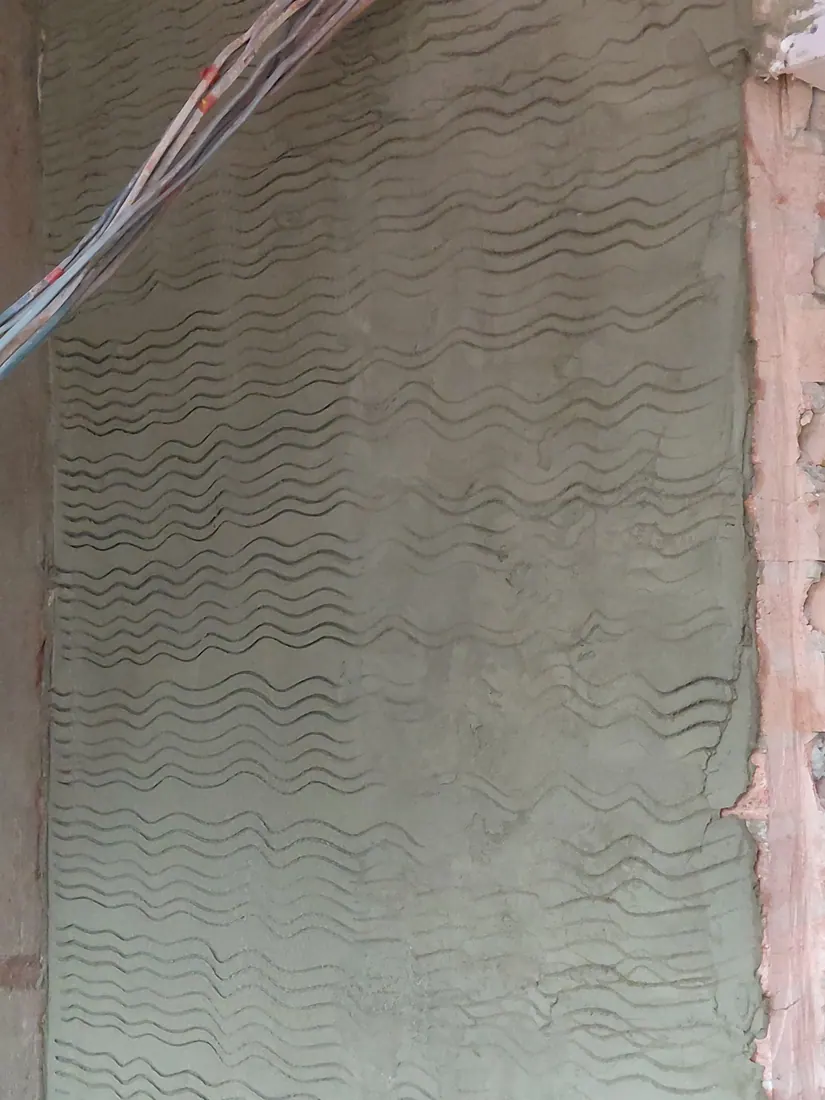 Close view of the keyed grooves on a rendering scratch coat