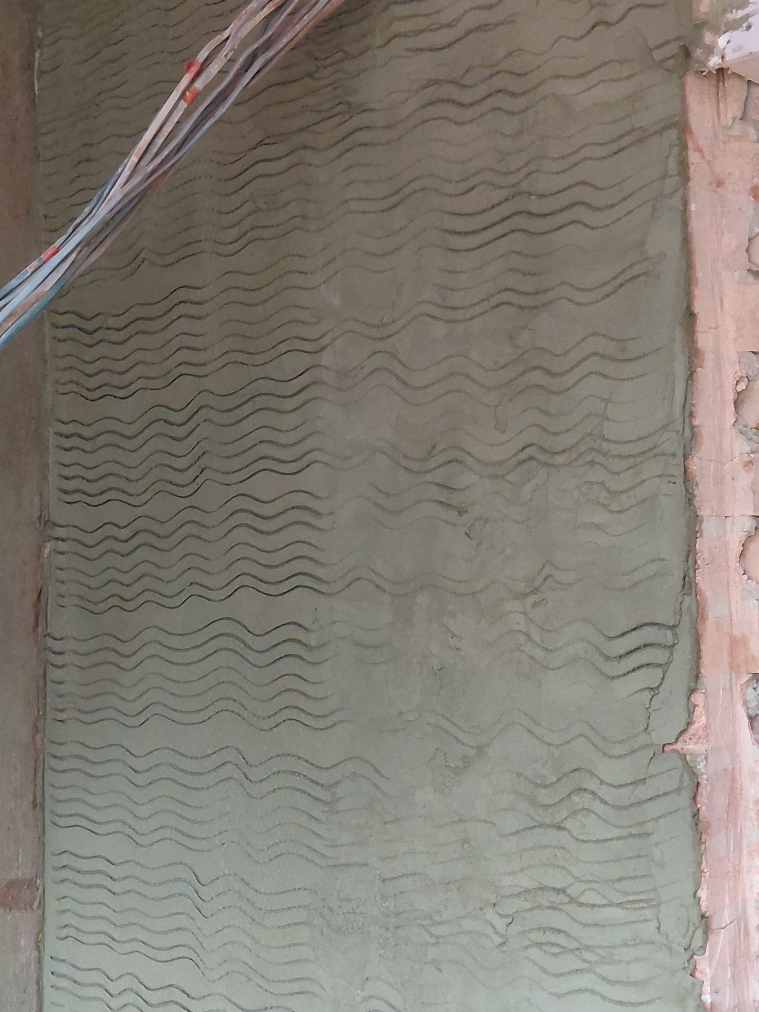 Close view of the keyed grooves on a rendering scratch coat