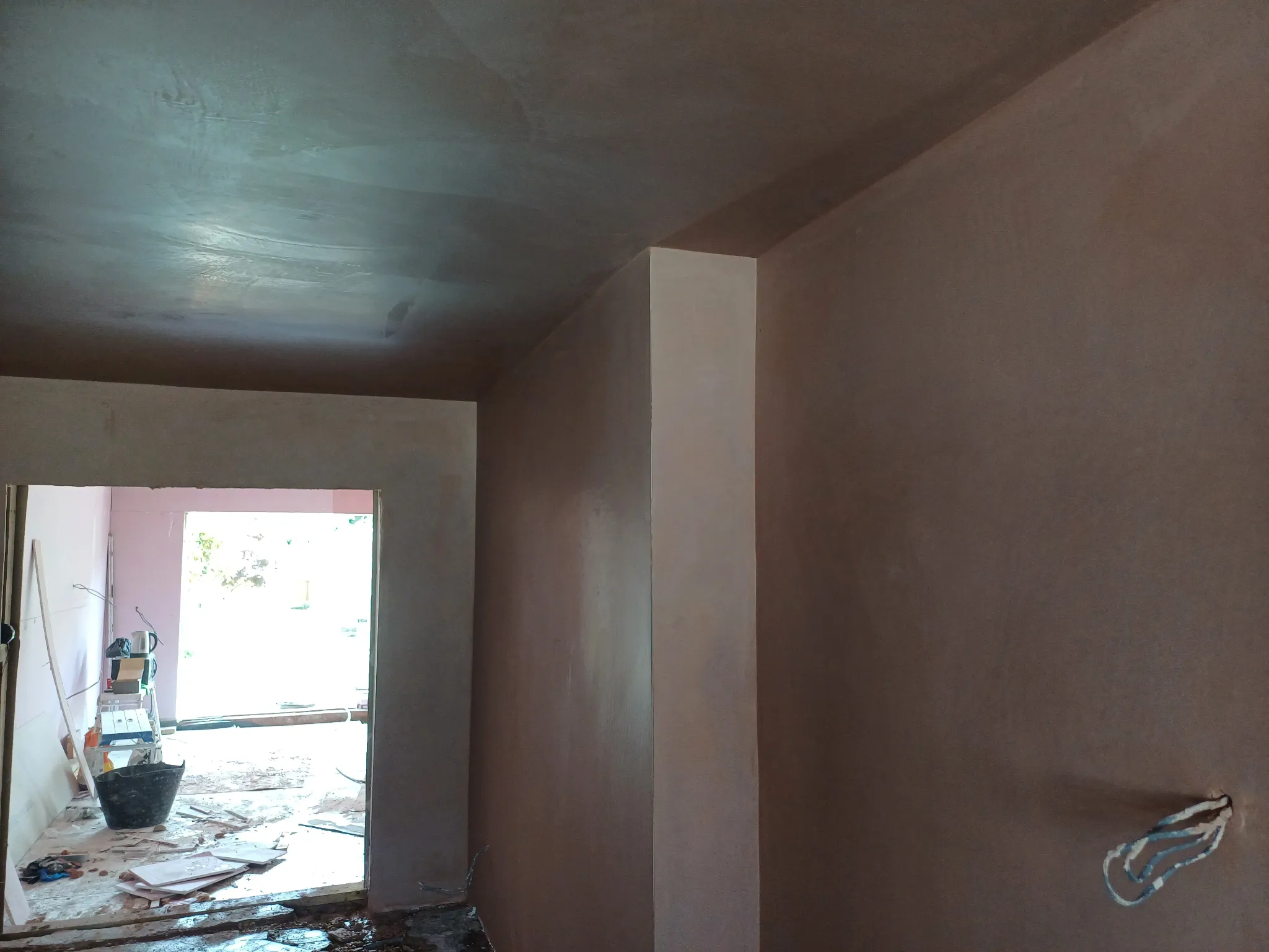 View through a room with freshly skimmed walls and ceiling