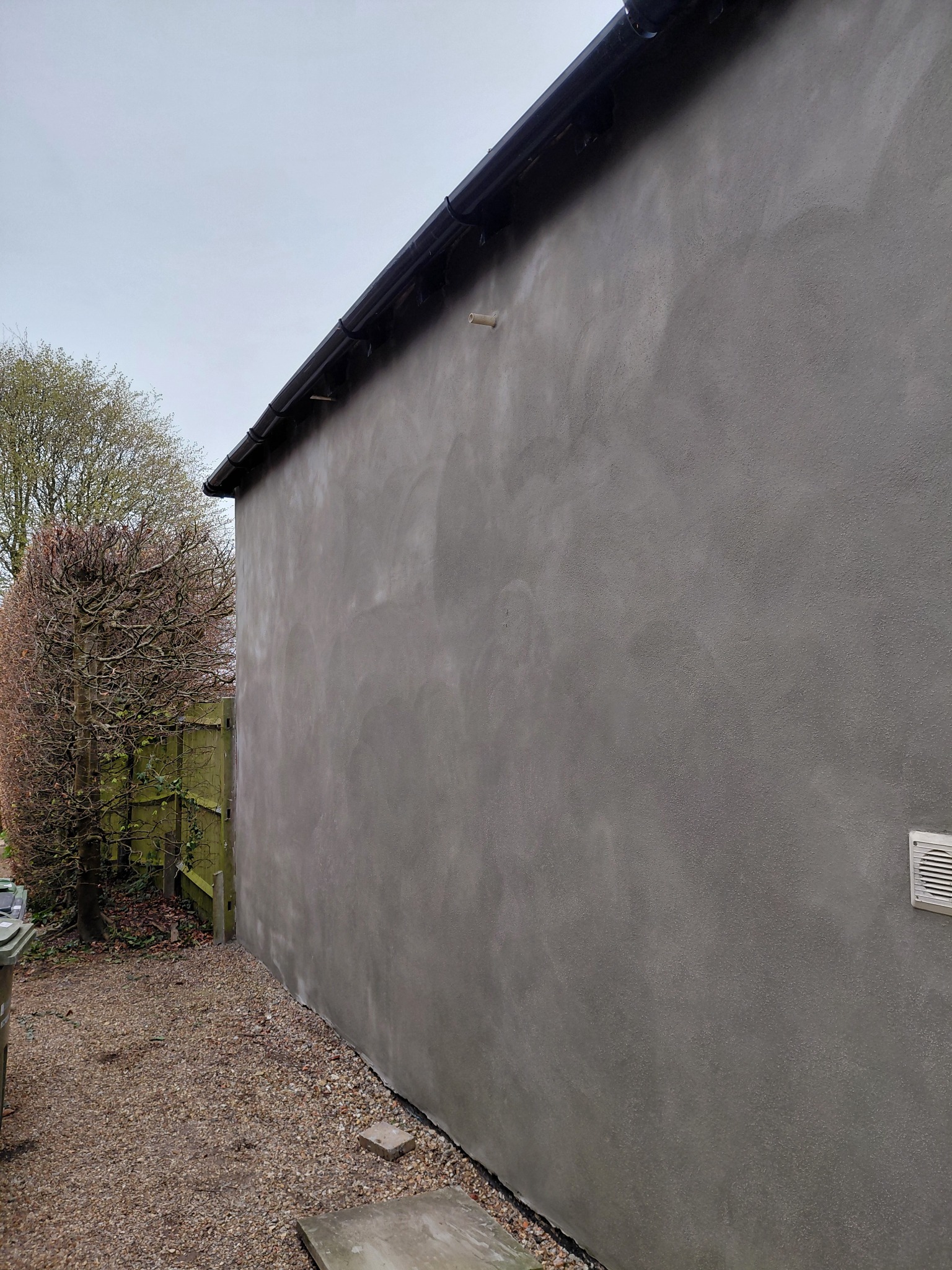 Sand and cement render finish on a long exterior wall