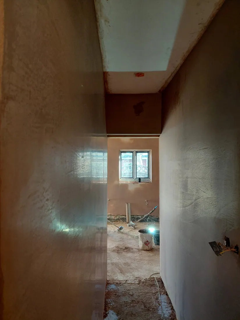 Smooth fresh plaster finish in a narrow hallway
