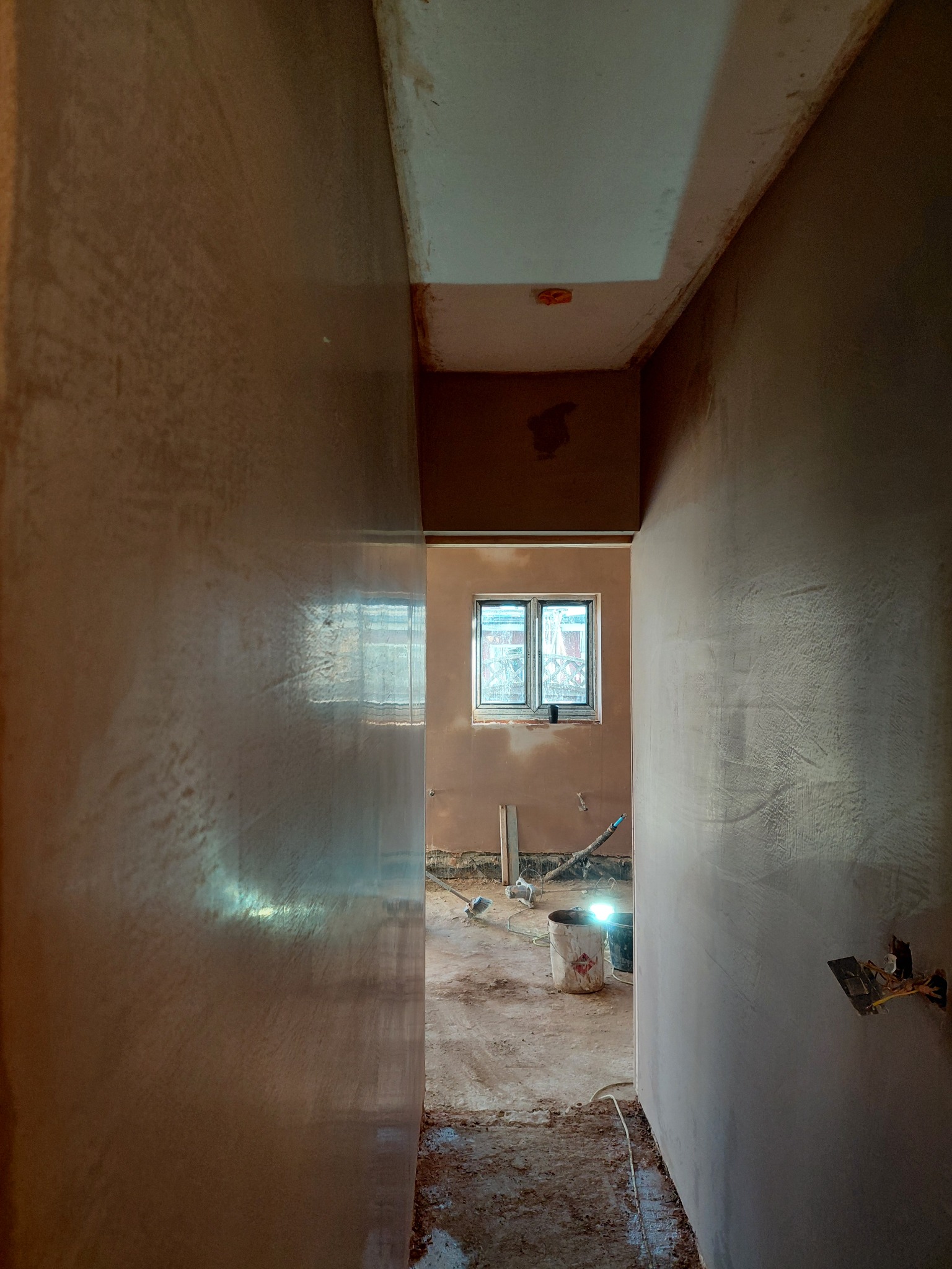 Smooth fresh plaster finish in a narrow hallway