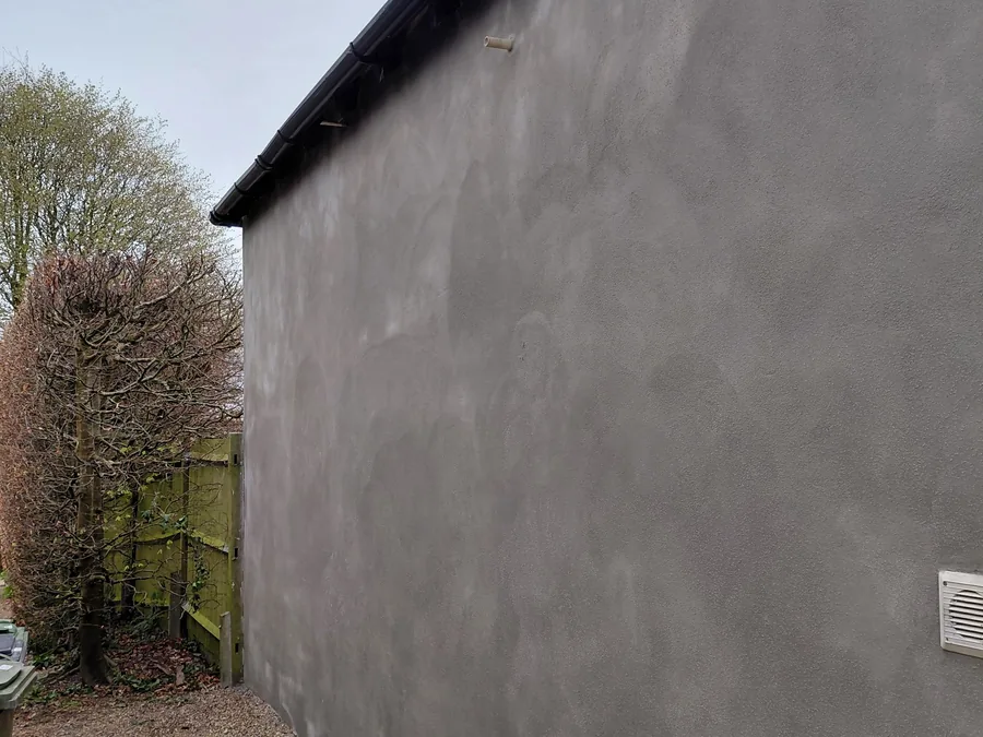 Sand and cement render base coat applied to an exterior wall.