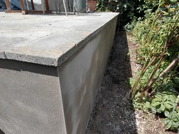 Textured exterior render on a garden retaining wall.