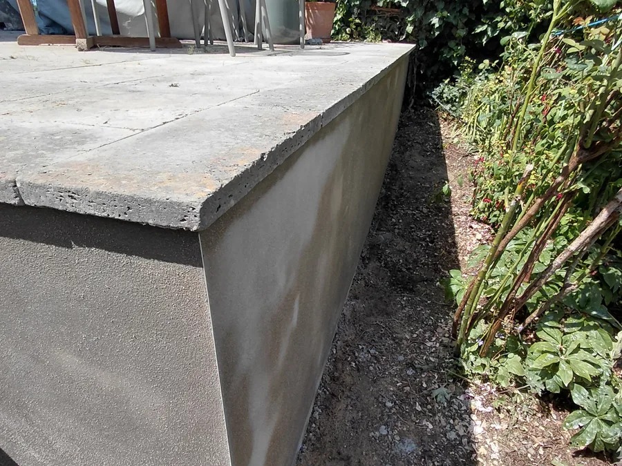 Textured exterior render on a garden retaining wall.