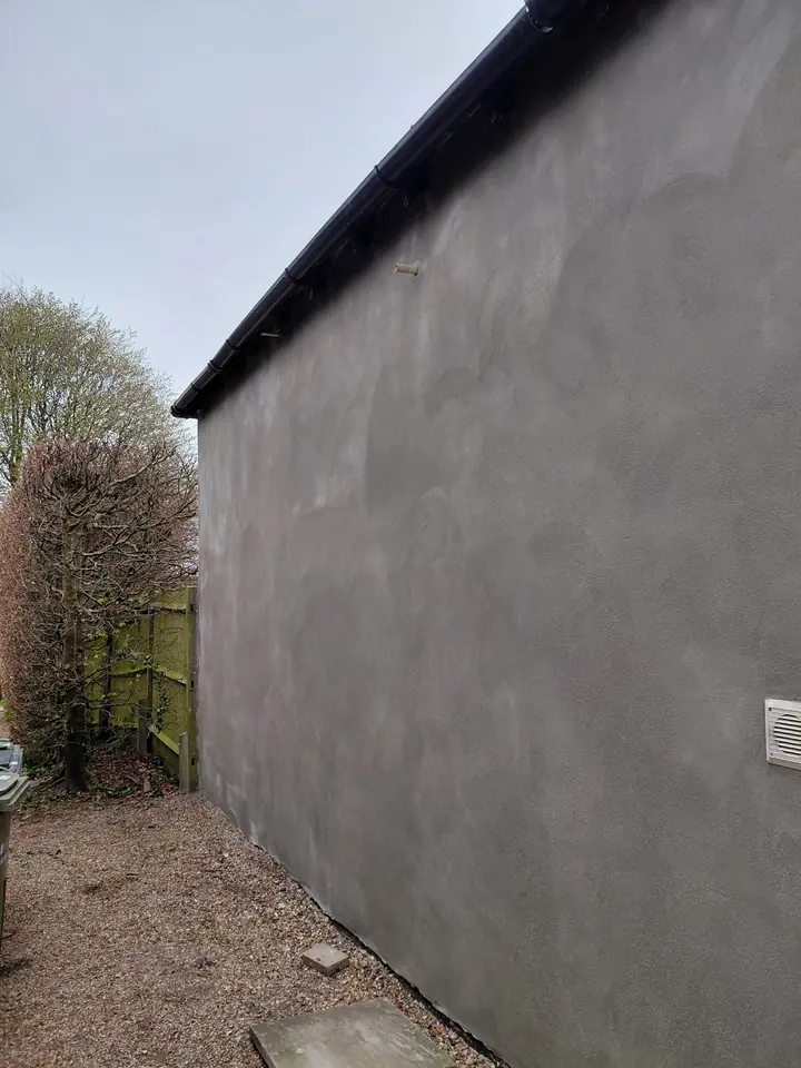 Sand and cement render finish on a long exterior wall