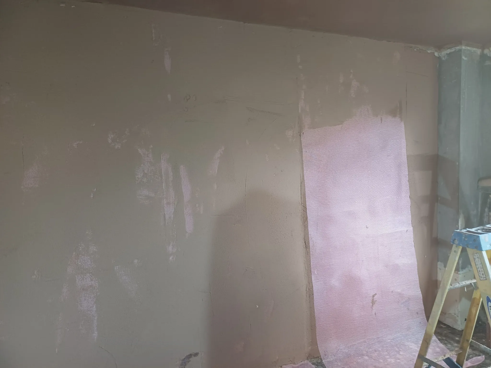Reinforcement mesh and prepared plaster on an interior wall